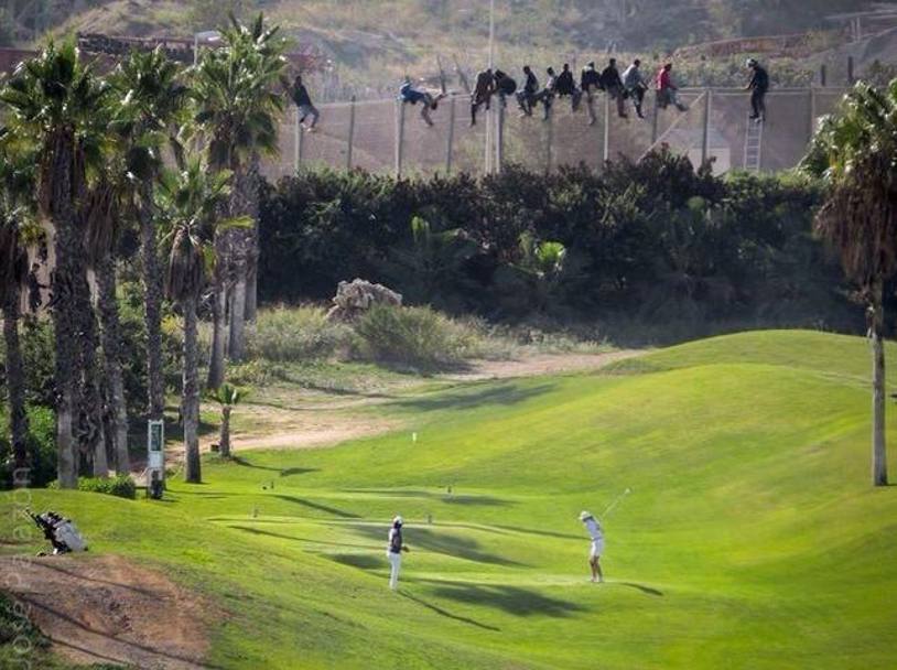 El Mundo apre il giornale con la foto che vedete qui intitolata: La recinzione della vergogna. Siamo a Melilla, la gente gioca a golf mentre sulla rete uomini africani cercano di scavalcare per entrare in Spagna dall&#39;Africa. Con un poliziotto armato di scala e manganello per cercare di dissuaderli. Un&#39;immagine davvero simbolica della realt attuale e delle disparit sociali: mentre il Sud del mondo disperato cerca un approdo, l&#39;Occidente prosegue indifferente a rilassarsi